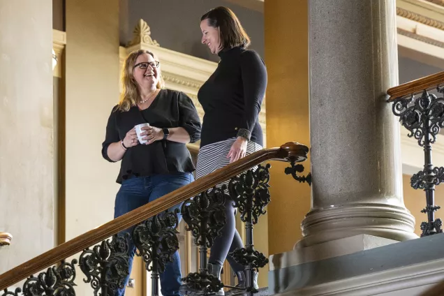 Två kvinnor går nerför trappan i Universitetshuset.